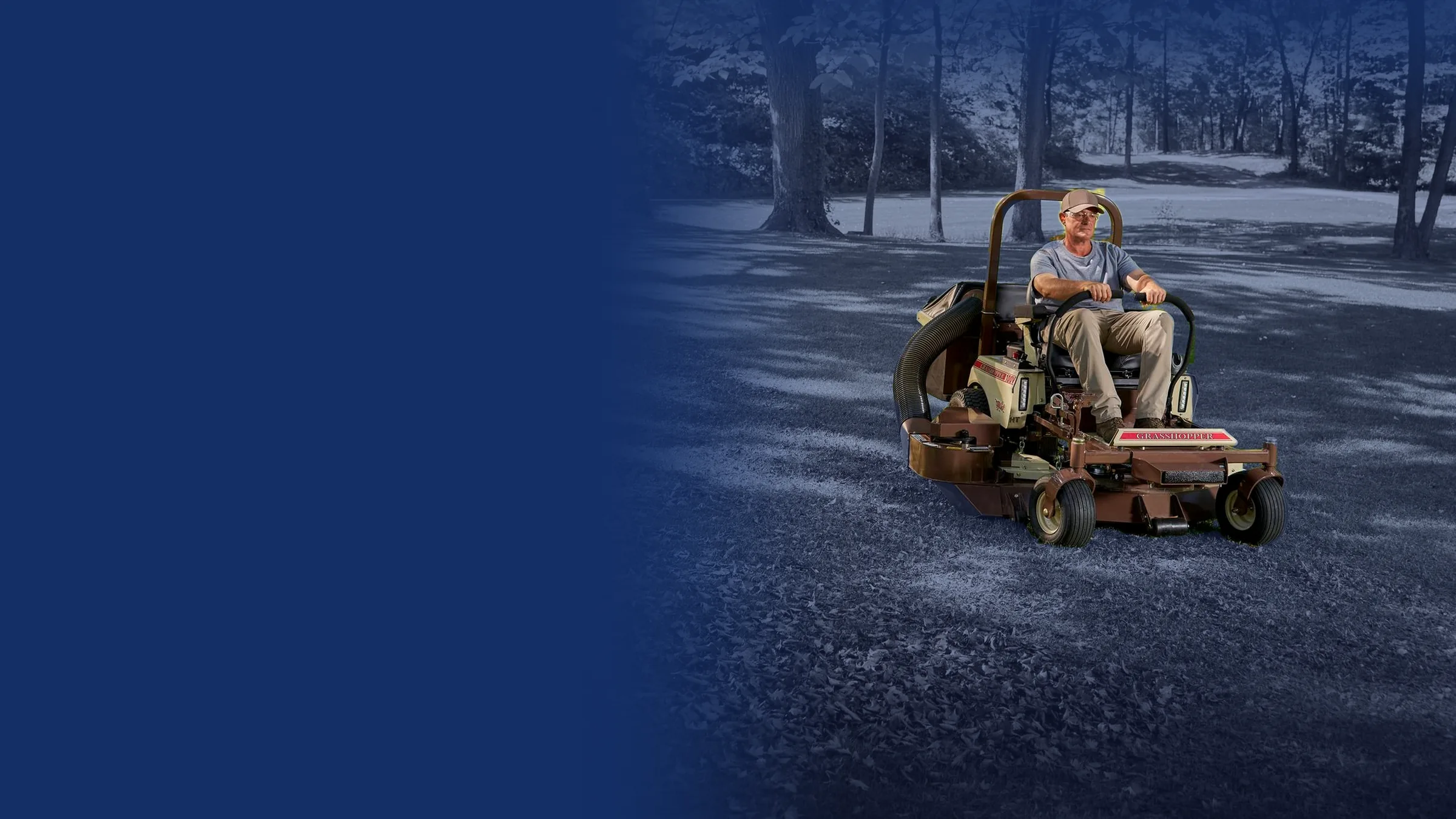 Operator mowing a fall lawn on a Grasshopper zero-turn mower with a leaf collection system