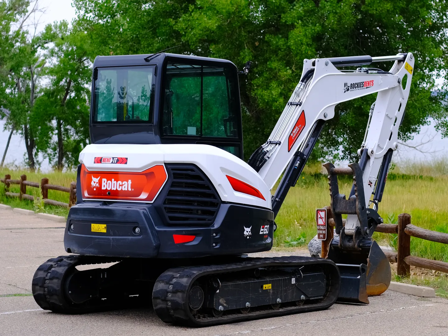Bobcat E60 compact excavator parked beside a lake