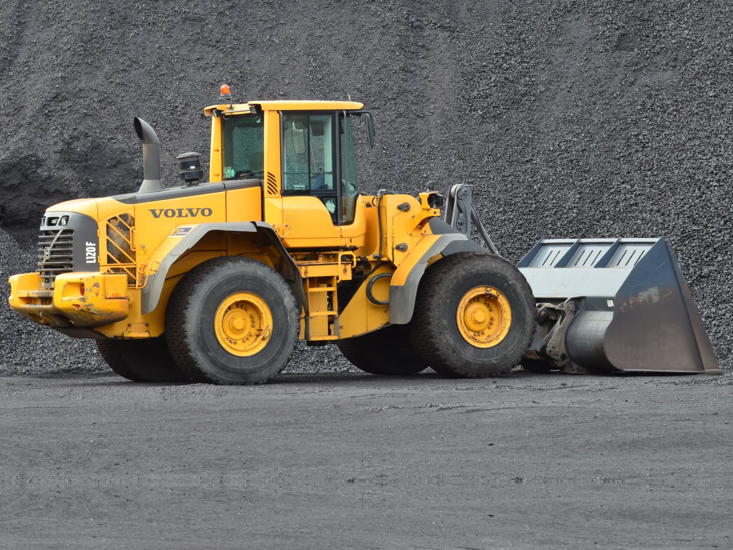 Volvo L120F wheel loader parked in front of a gravel pile