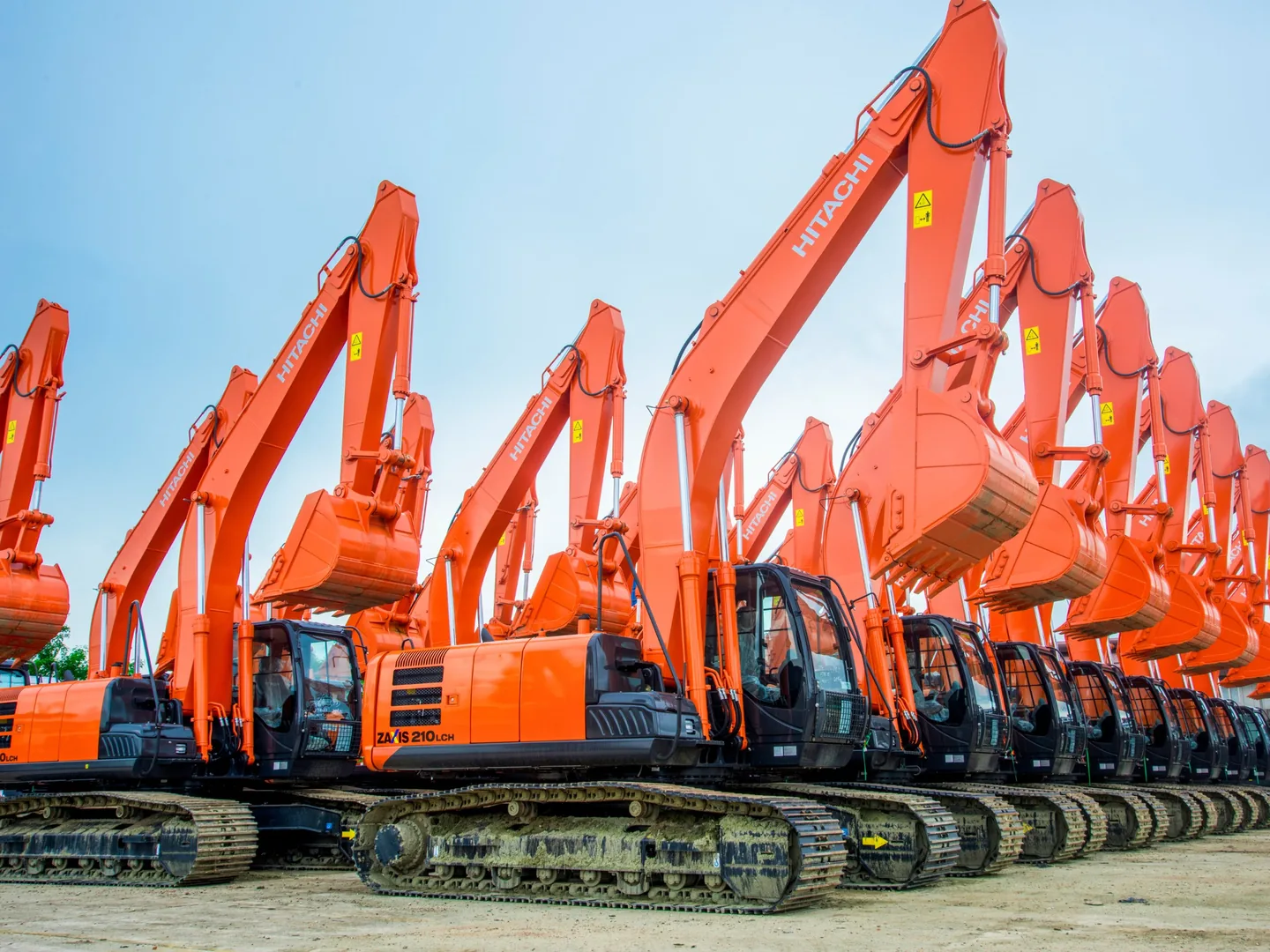 Row of new Hitachi ZX210LCH excavators with booms raised