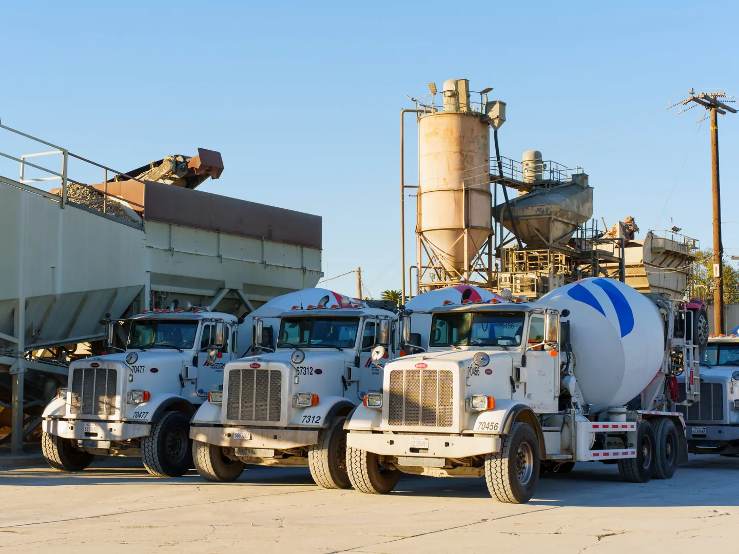 Fleet of Peterbilt concrete mixer trucks lined up at a ready-mix plant