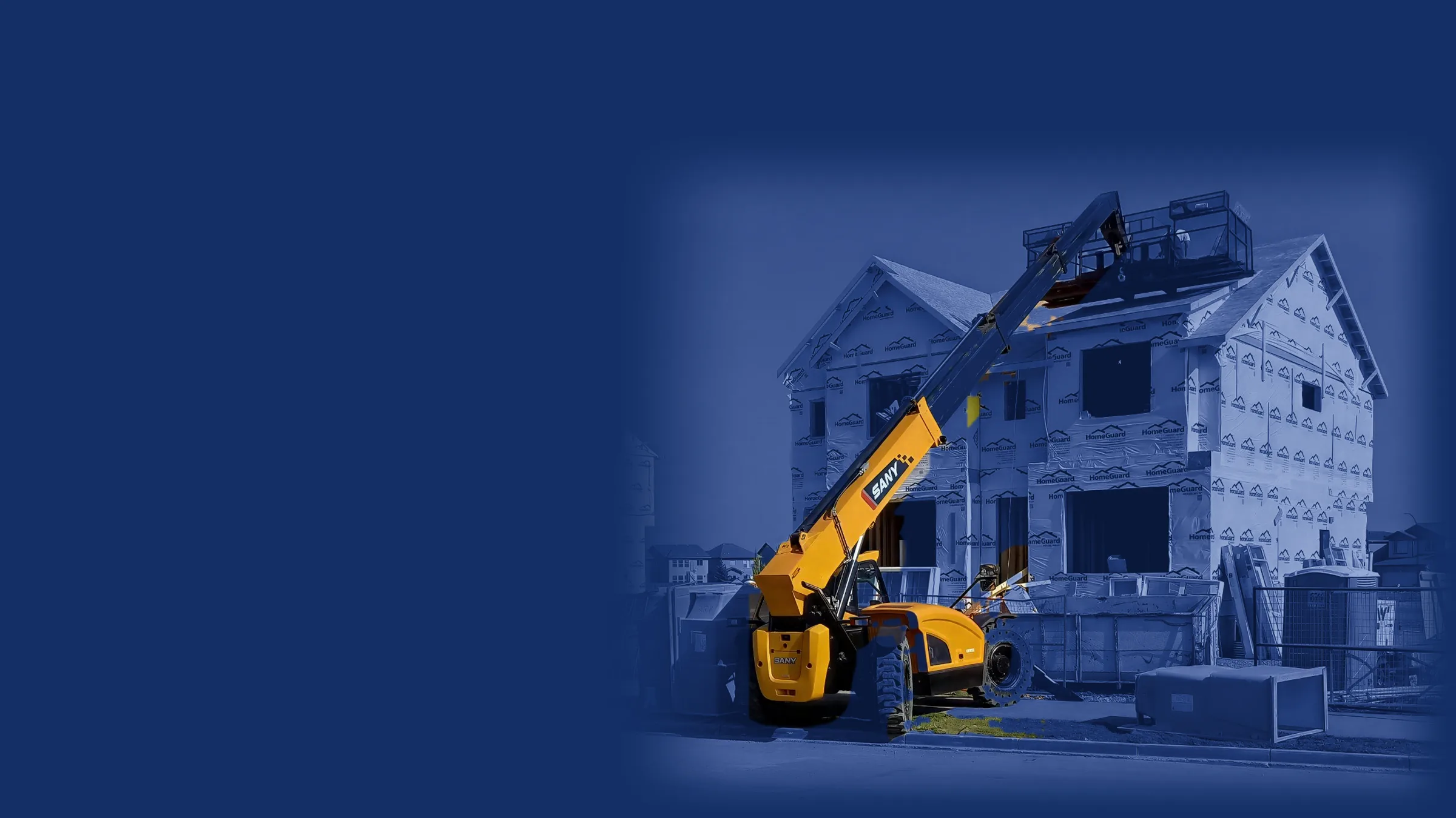 Yellow SANY telehandler parked in front of a two-story house under construction