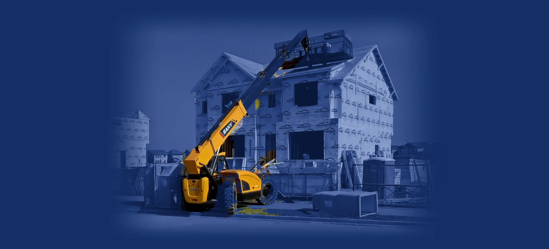 Yellow SANY telehandler parked in front of a two-story house under construction