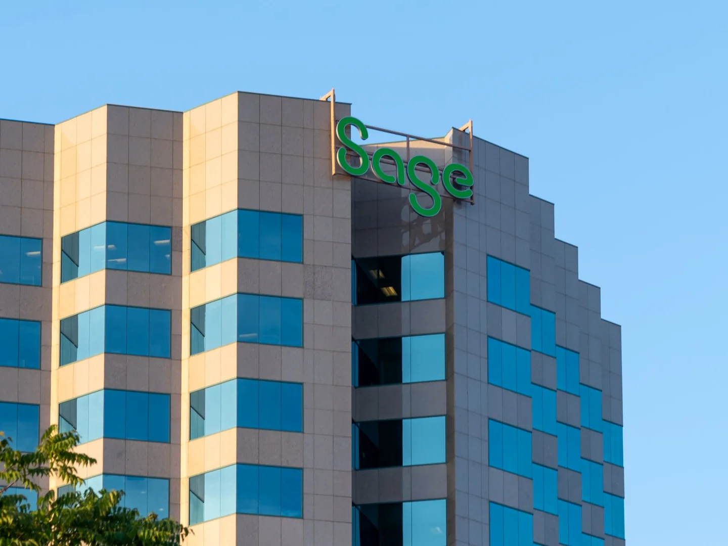 Sage office tower with the green Sage logo against a blue sky