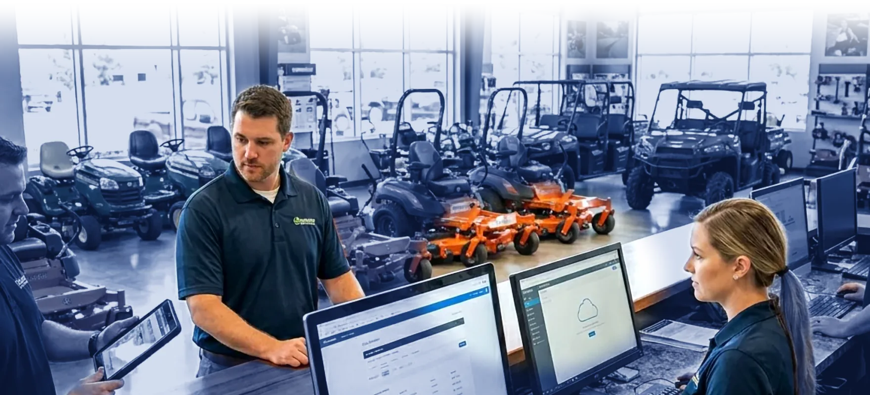 Dealership counter team working at computers in an equipment showroom