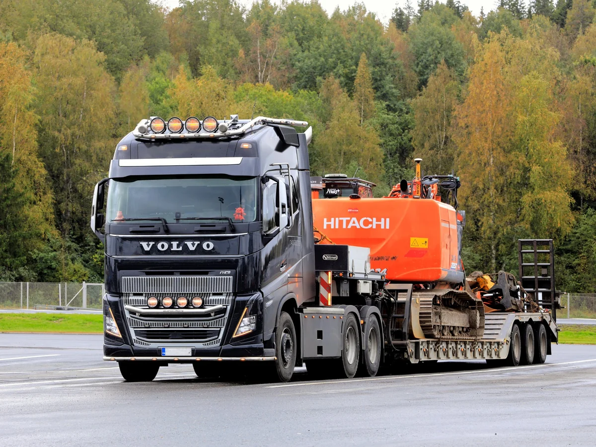 Volvo truck hauling an excavator on a lowboy trailer