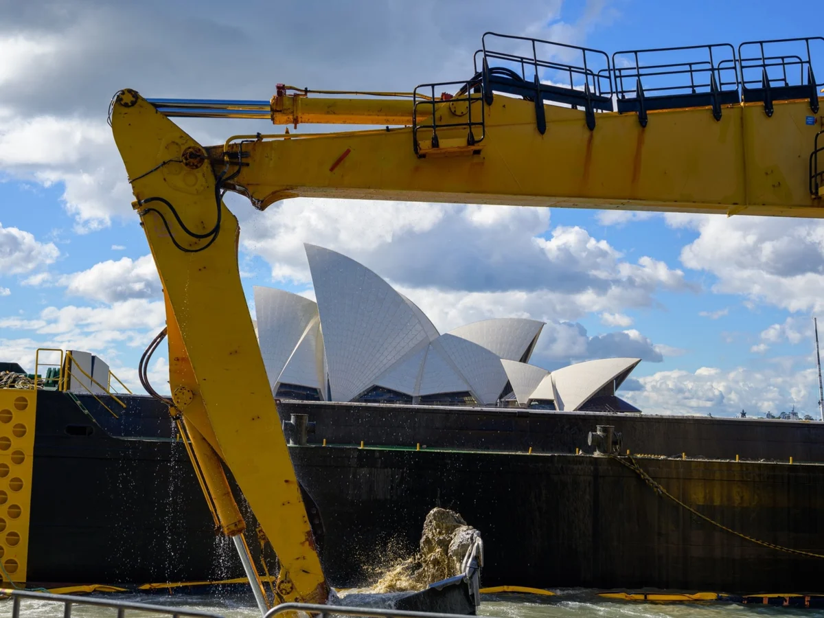 Long-reach excavator arm working on Sydney Harbour with the Opera House behind it