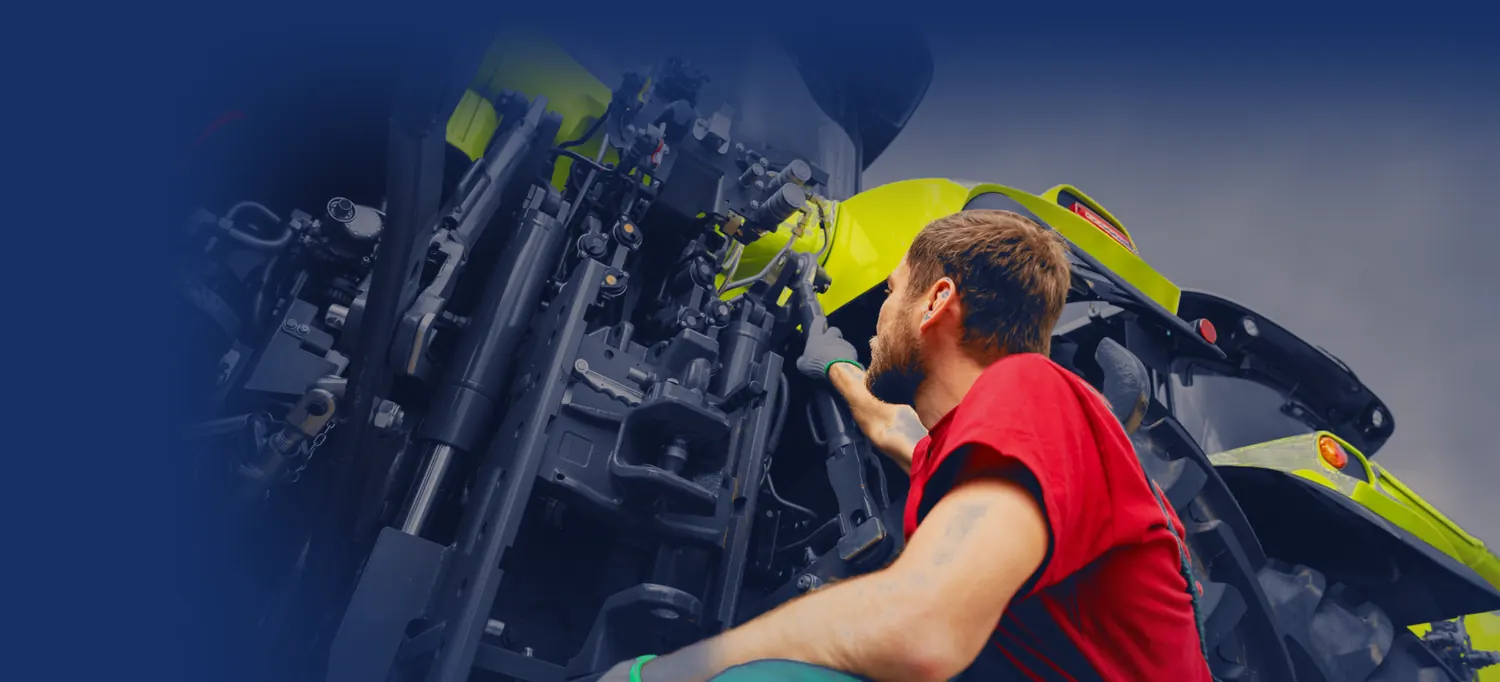 Technician working on the rear hitch of a tractor