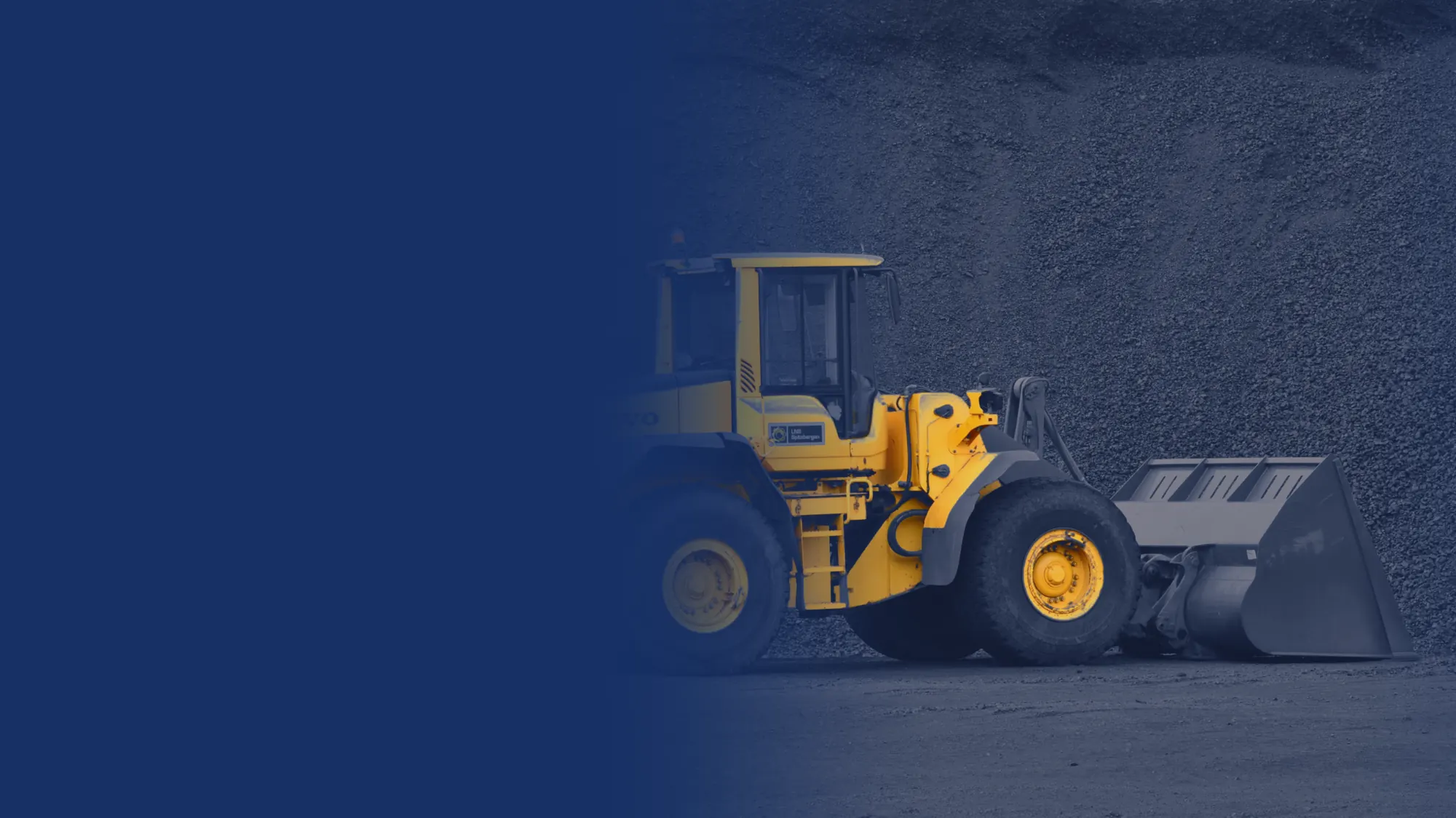 Volvo wheel loader in front of a stockpile of crushed stone