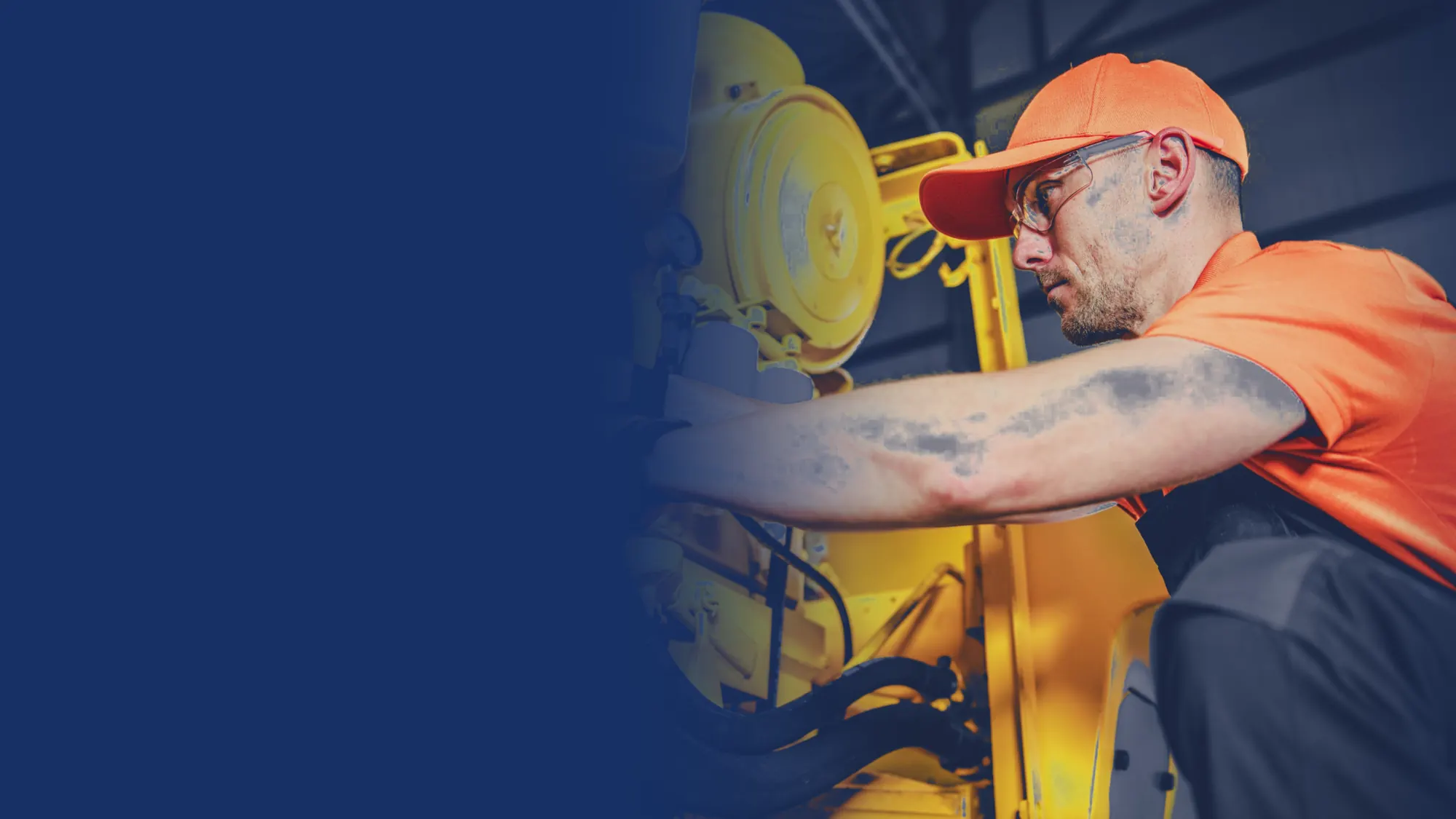 Technician in safety glasses working on a heavy equipment engine
