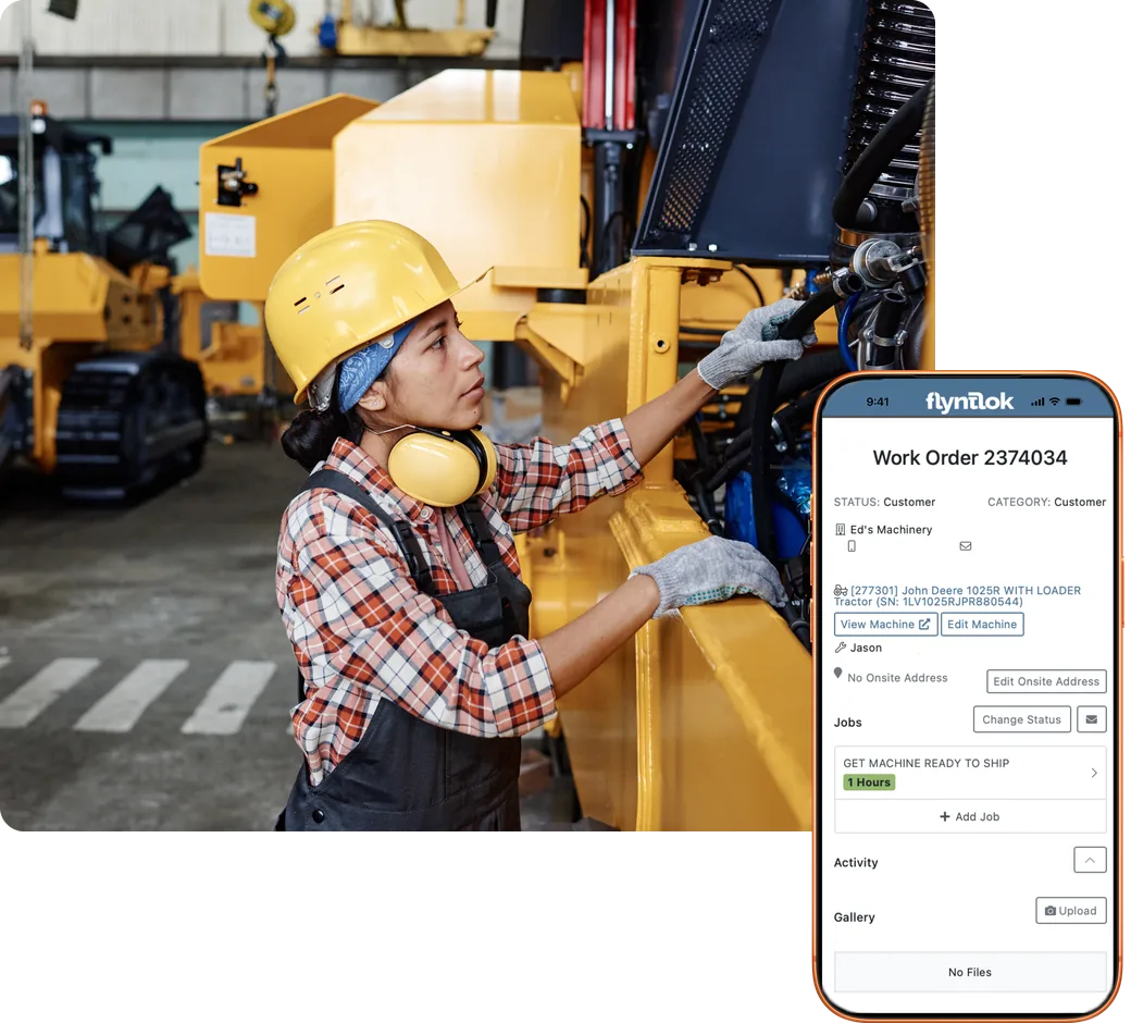 Technician in a hard hat working on a machine in the service bay, next to a Flyntlok mobile work order on a phone