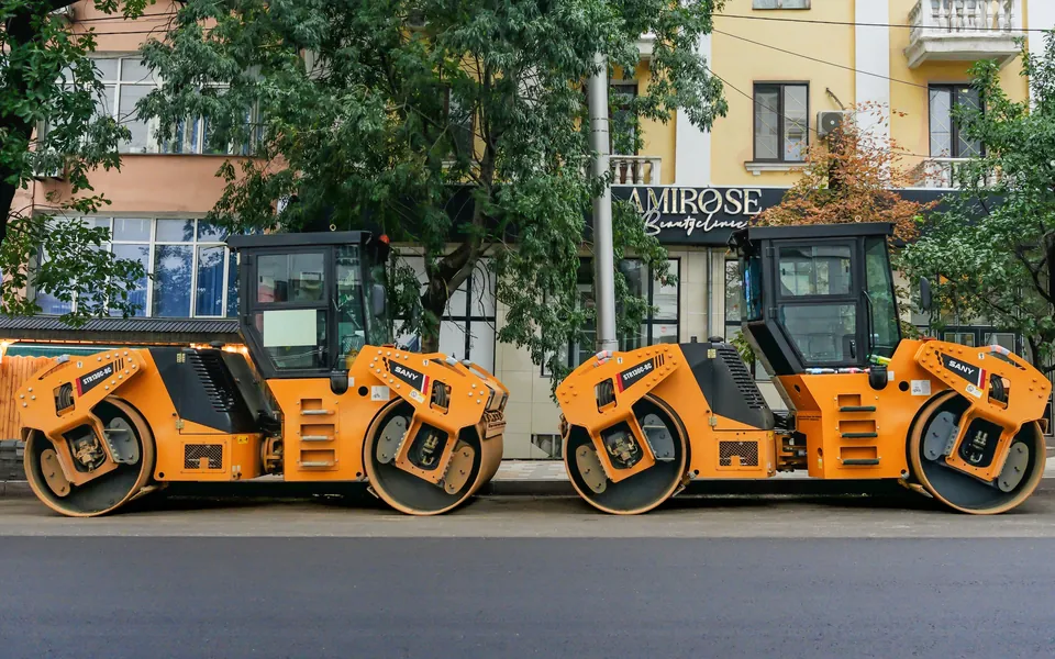 Two SANY double-drum rollers parked on a city street