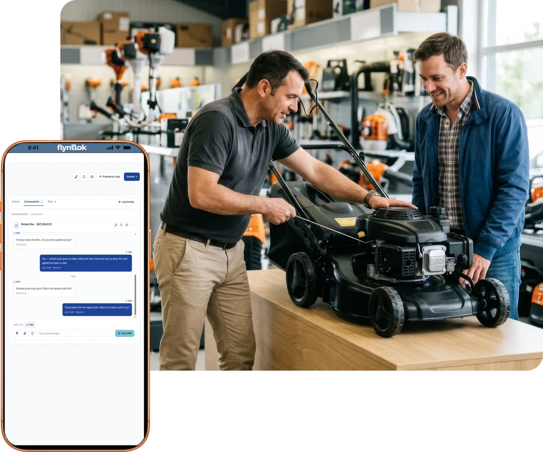 Salesperson showing a customer a push mower at the counter, beside a phone with a Flyntlok text conversation