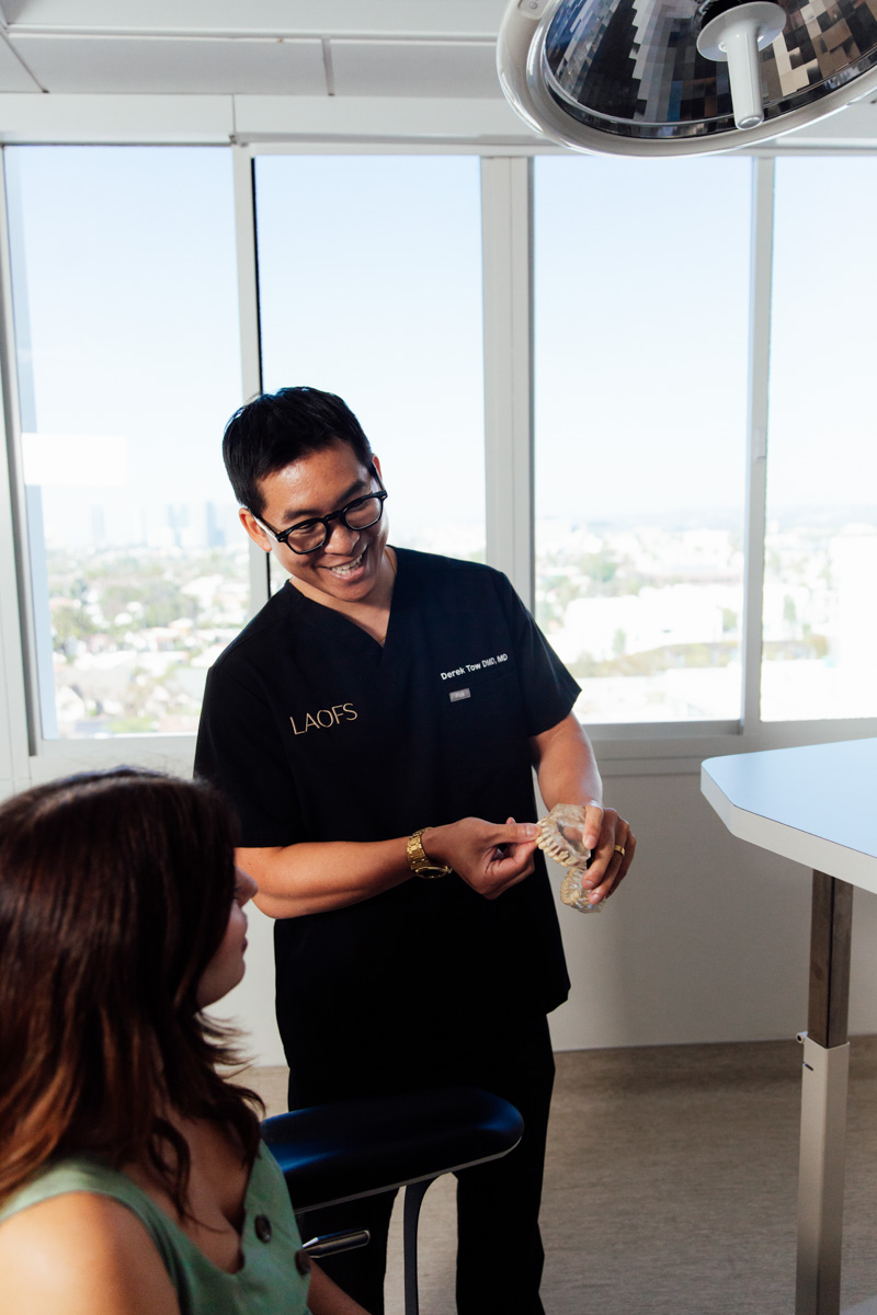 Dr. Tow talking with a patient in an operatory at Los Angeles Oral & Facial Surgery.