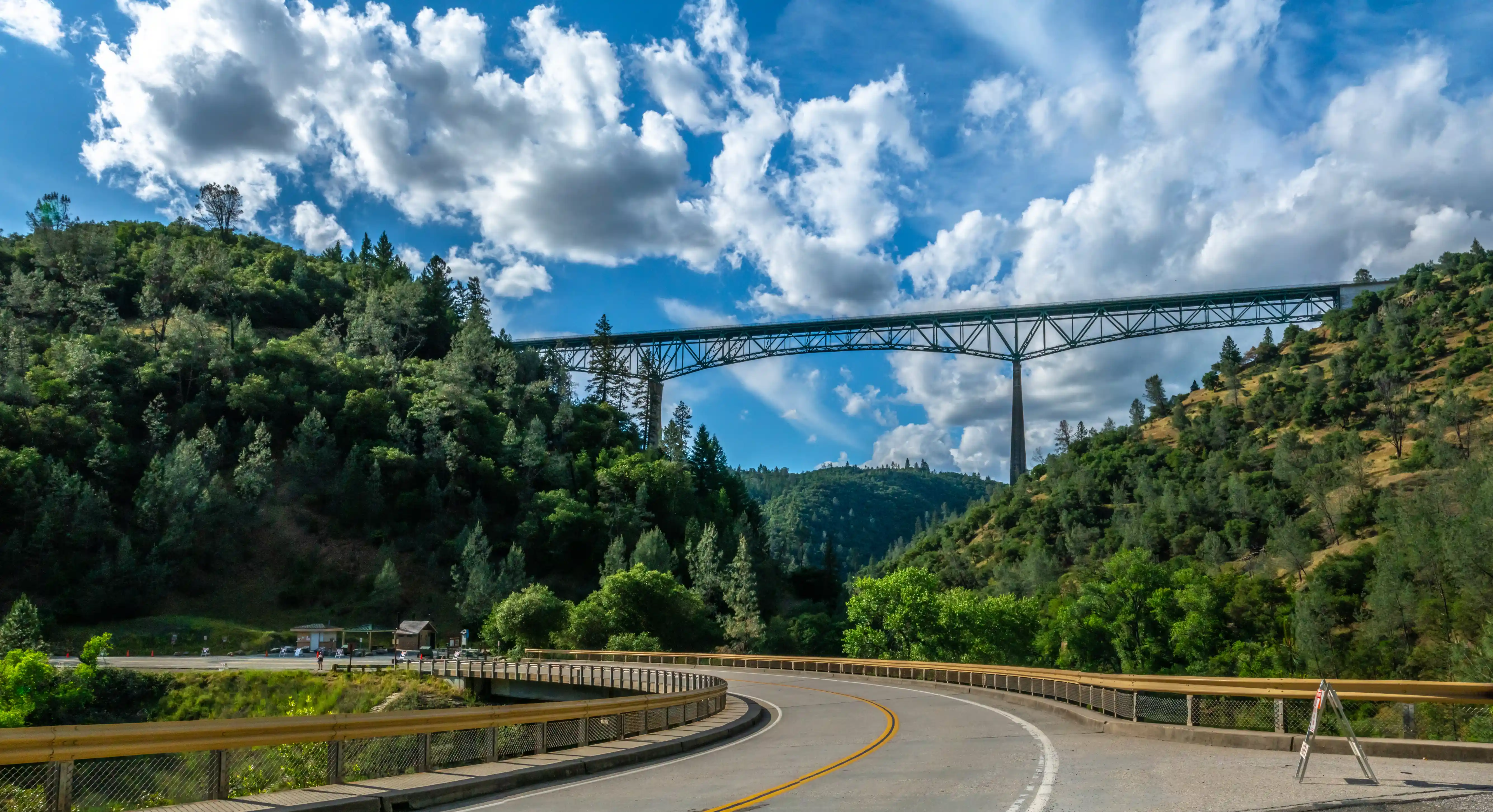 a road that is turning with a bridge that is high up in the distance in placer county