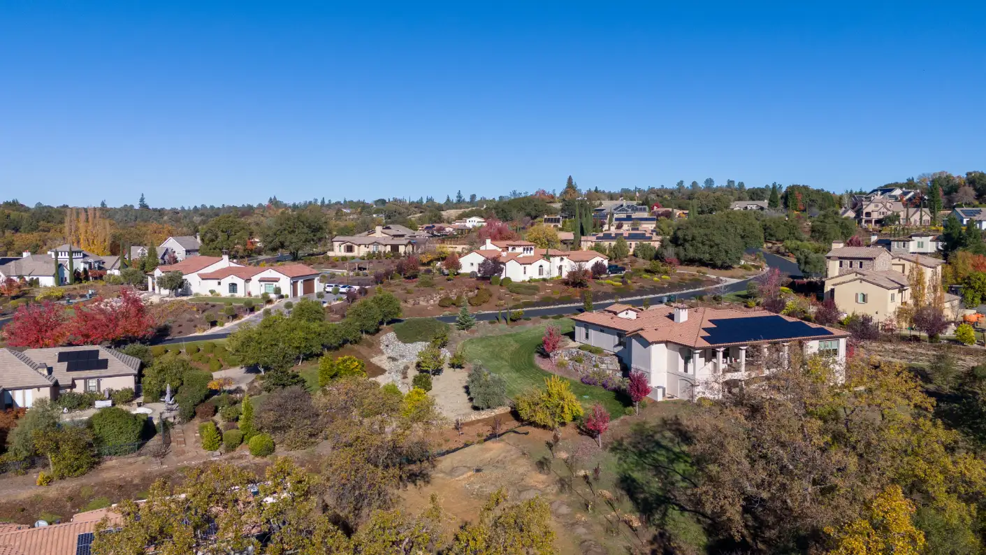 Suburban bliss in Auburn, CA with spacious homes along tree-lined streets and gentle hills.