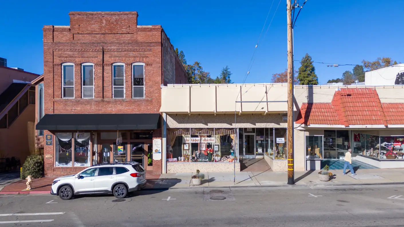 Street view of historic brick buildings with retail shops in downtown Auburn, CA.