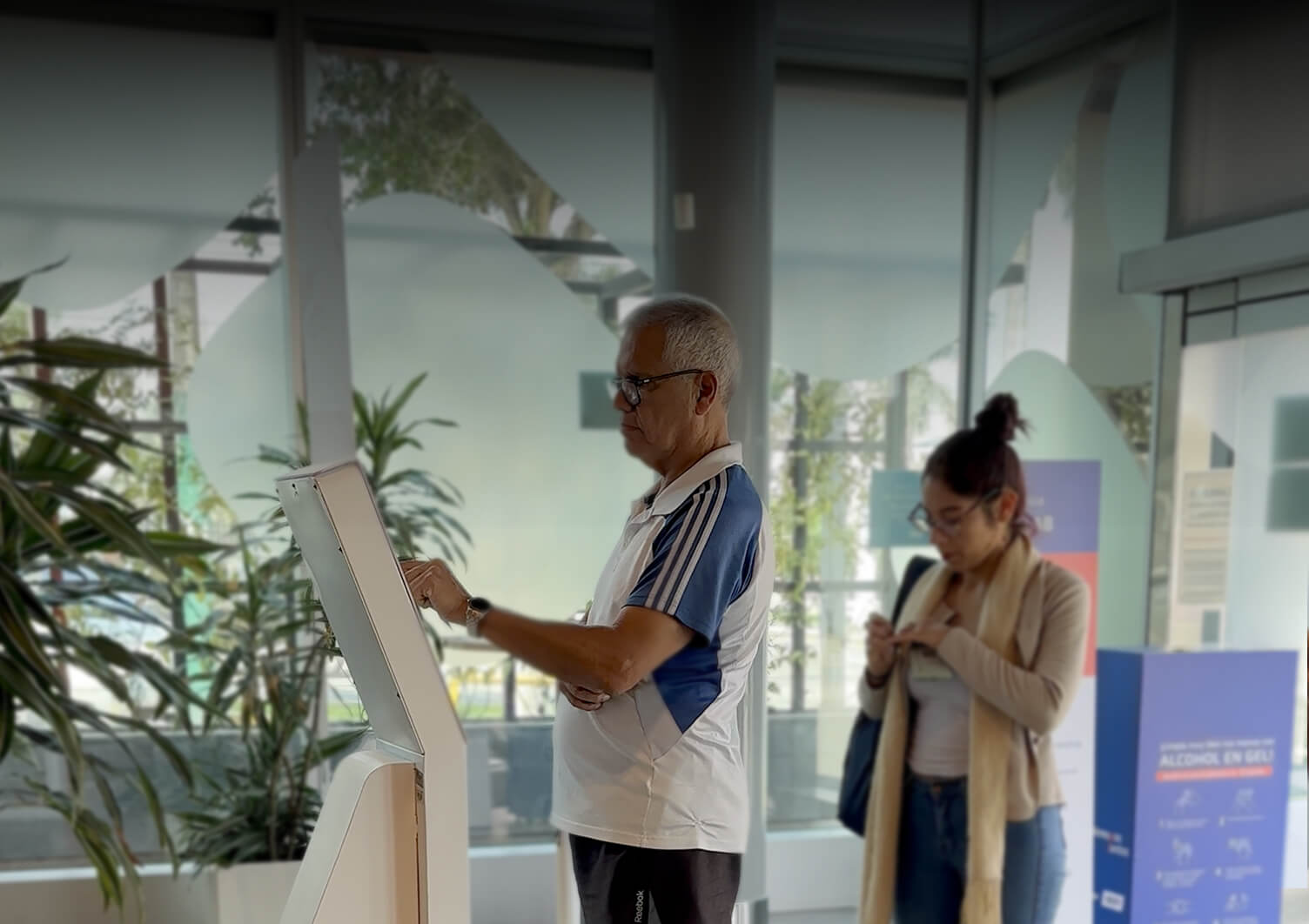 Users interacting with a self-service kiosk illustrating real-world application of a system-driven design approach