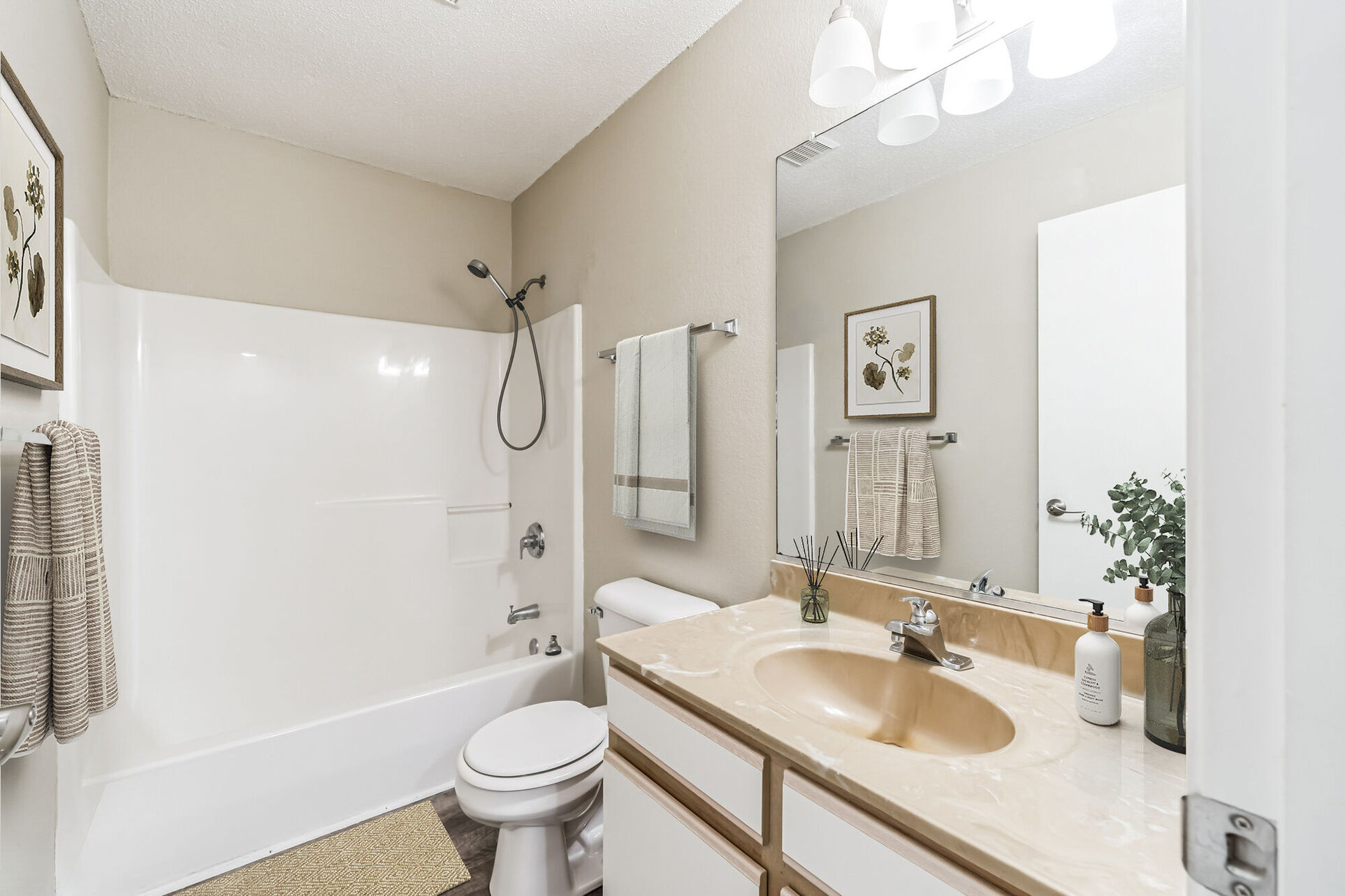 Bathroom with tub shower combo and brown and white vanity