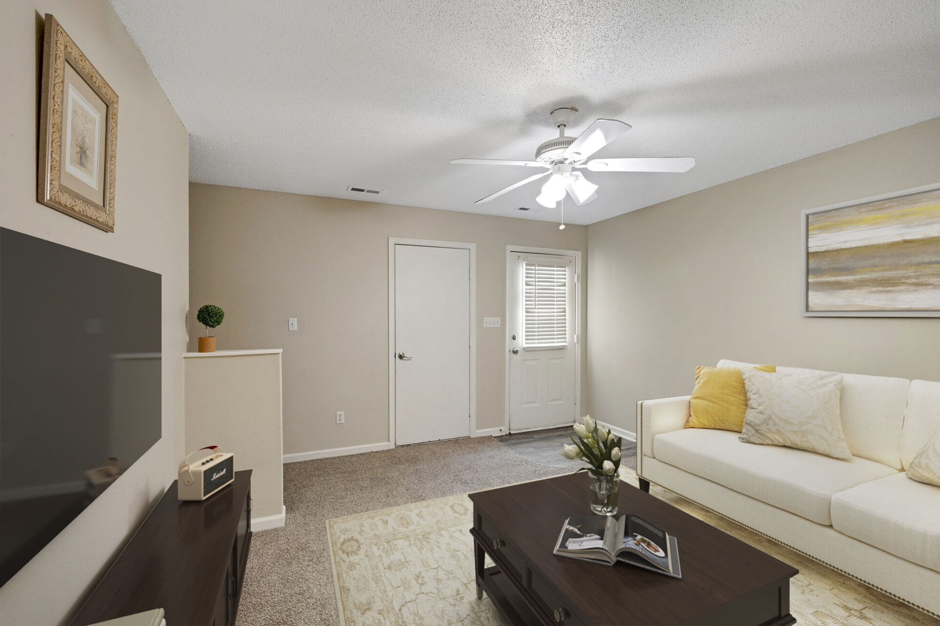 Living area with sofa, coffee table, and tv with view of entrance