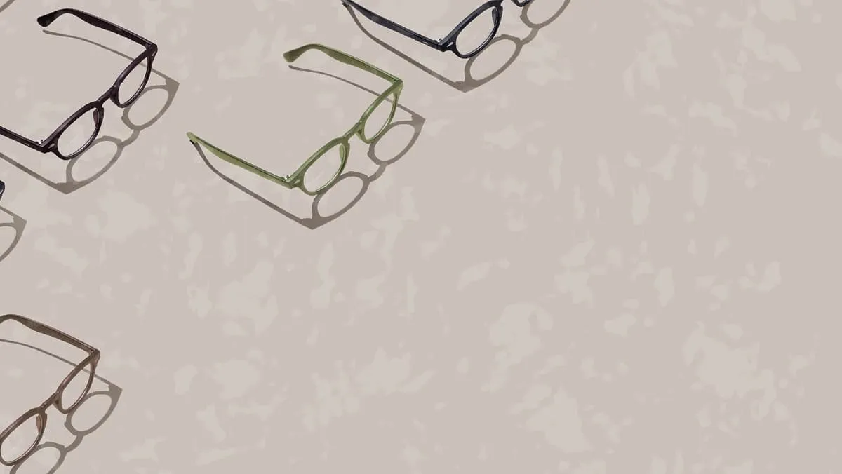 Four pairs of eyeglasses in black, green, brown, and navy with shadows on a beige surface.