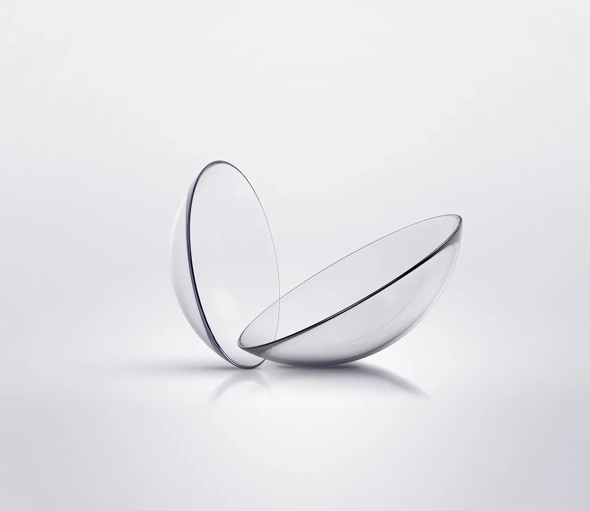 Two clear, round contact lenses placed on a white surface.