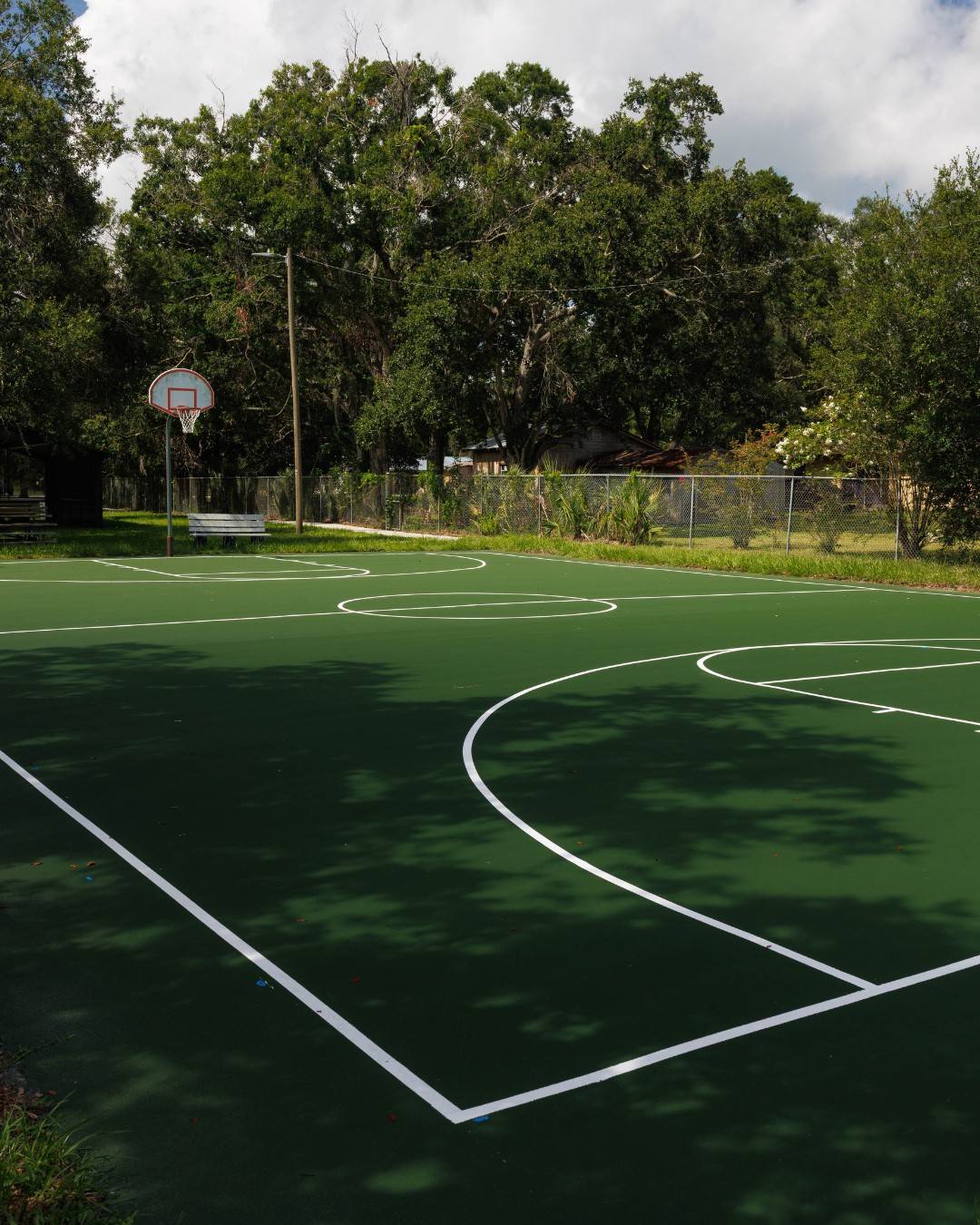 Clean single-color acrylic basketball court surface with fresh line striping in Bartow, FL