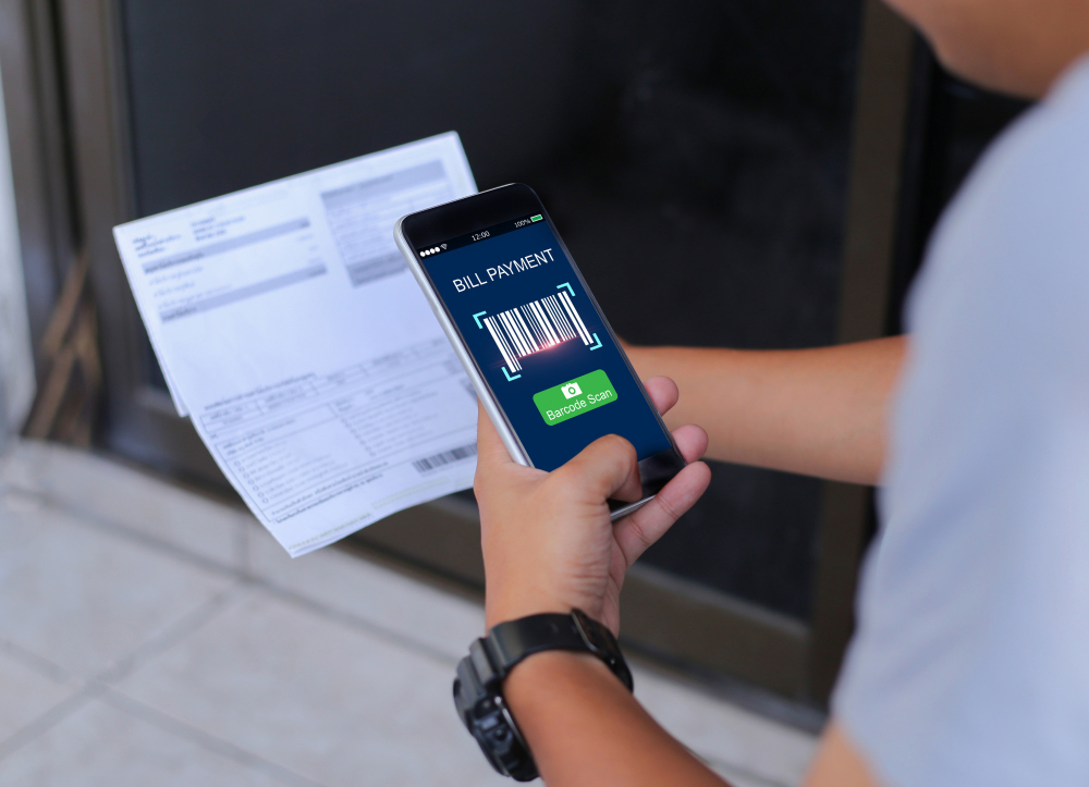Čovjek drži telefon i plaća račun skeniranjem qr koda