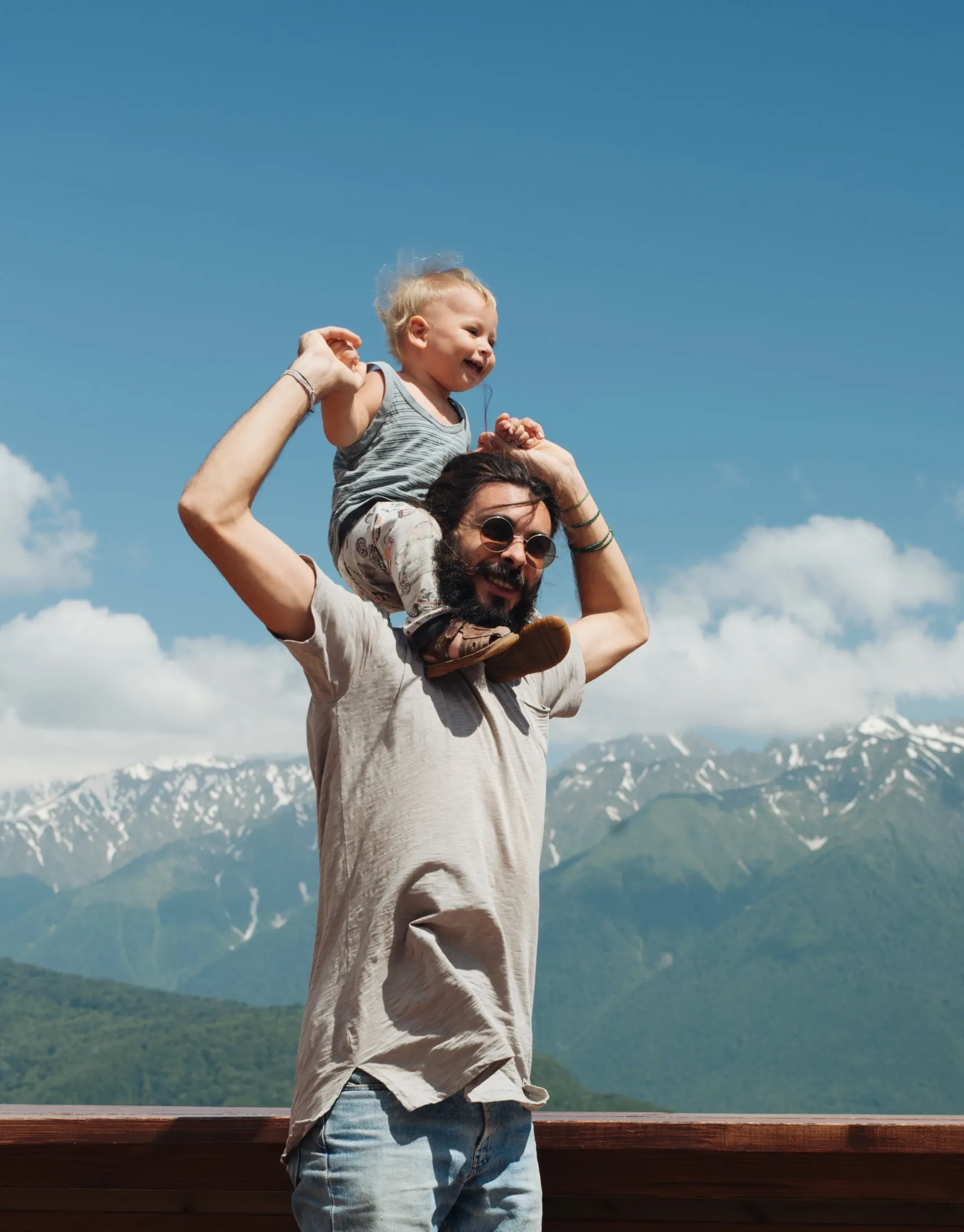 Dad with child on shoulders in front of mountains