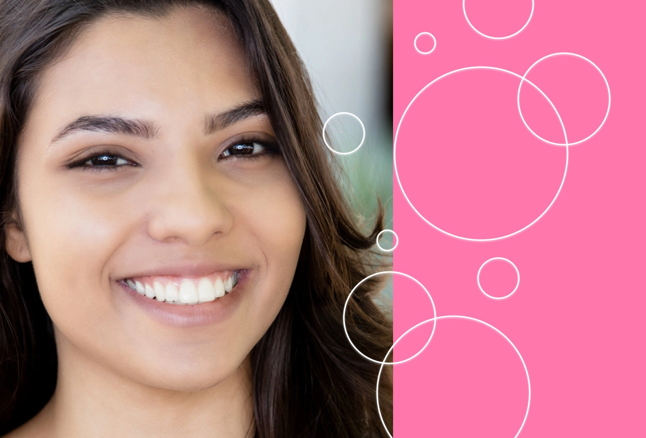 Smiling woman with dark hair beside white circles on hot pink background