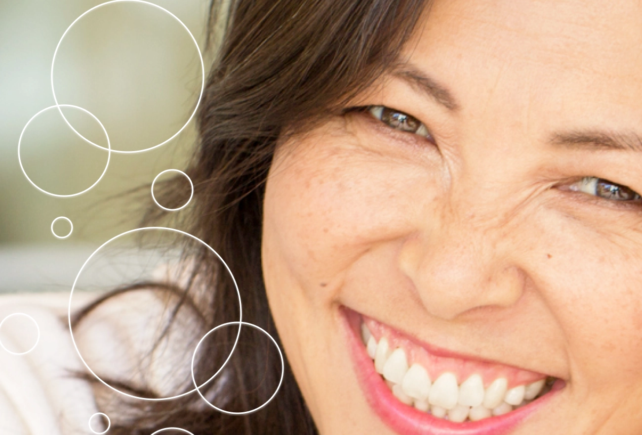 Woman smiling with white magnifying circles highlighting skin texture on left side