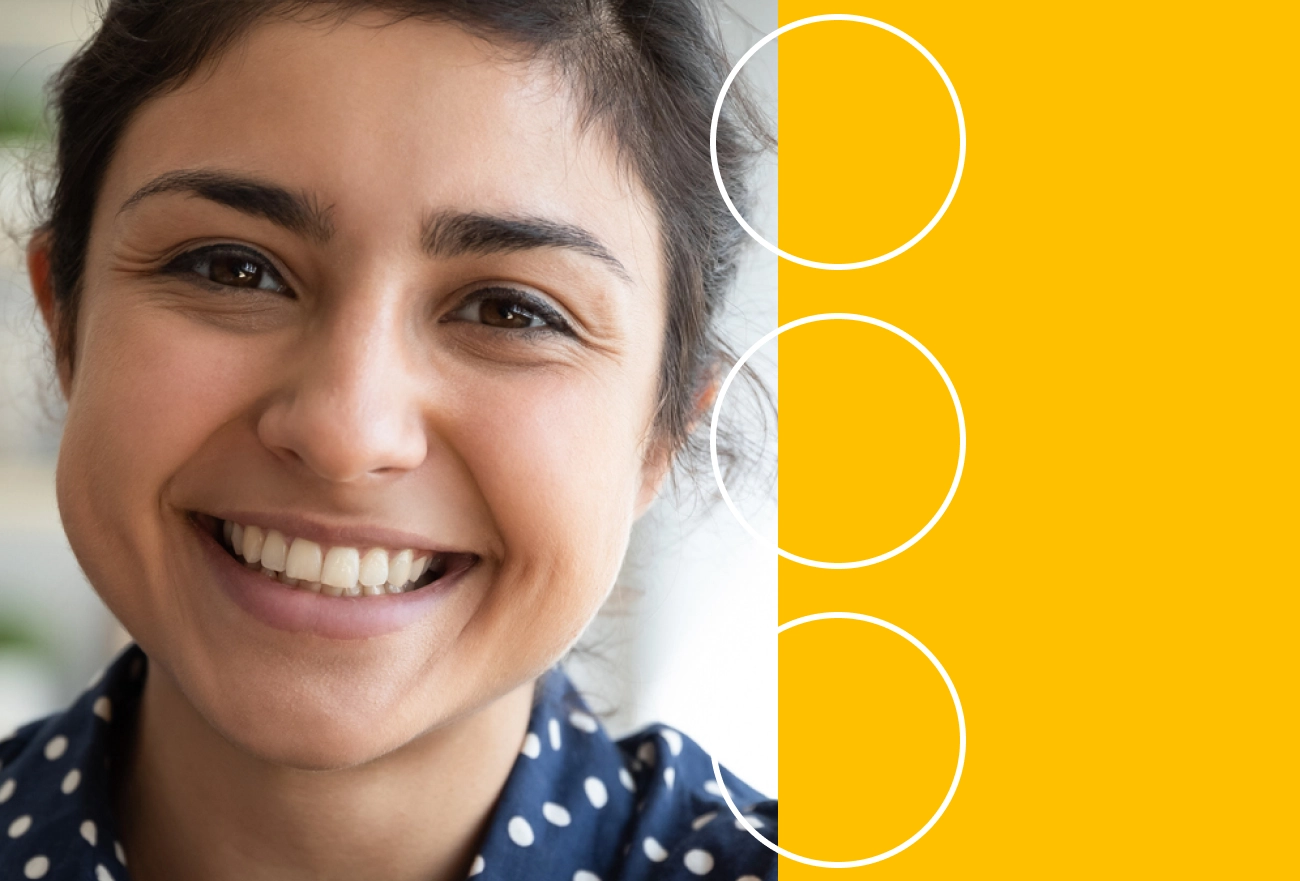 Woman smiling in blue polka dot shirt next to yellow background with three white circles