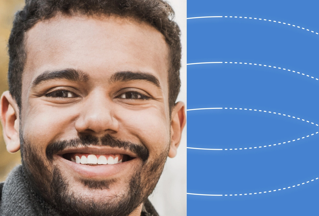 Smiling man's face with white dashed measurement lines on blue background indicating facial features