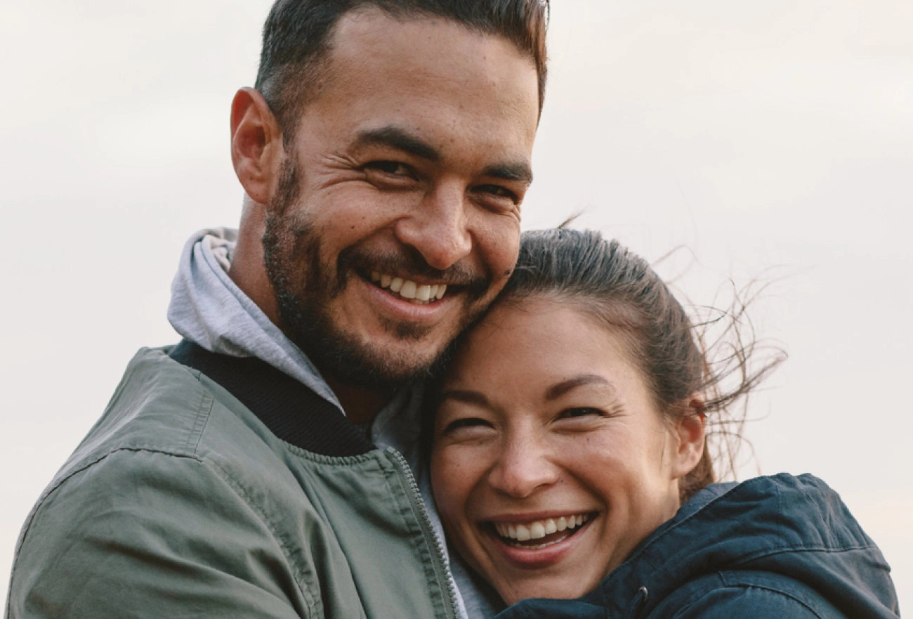 Man and woman smiling together outdoors in casual jackets