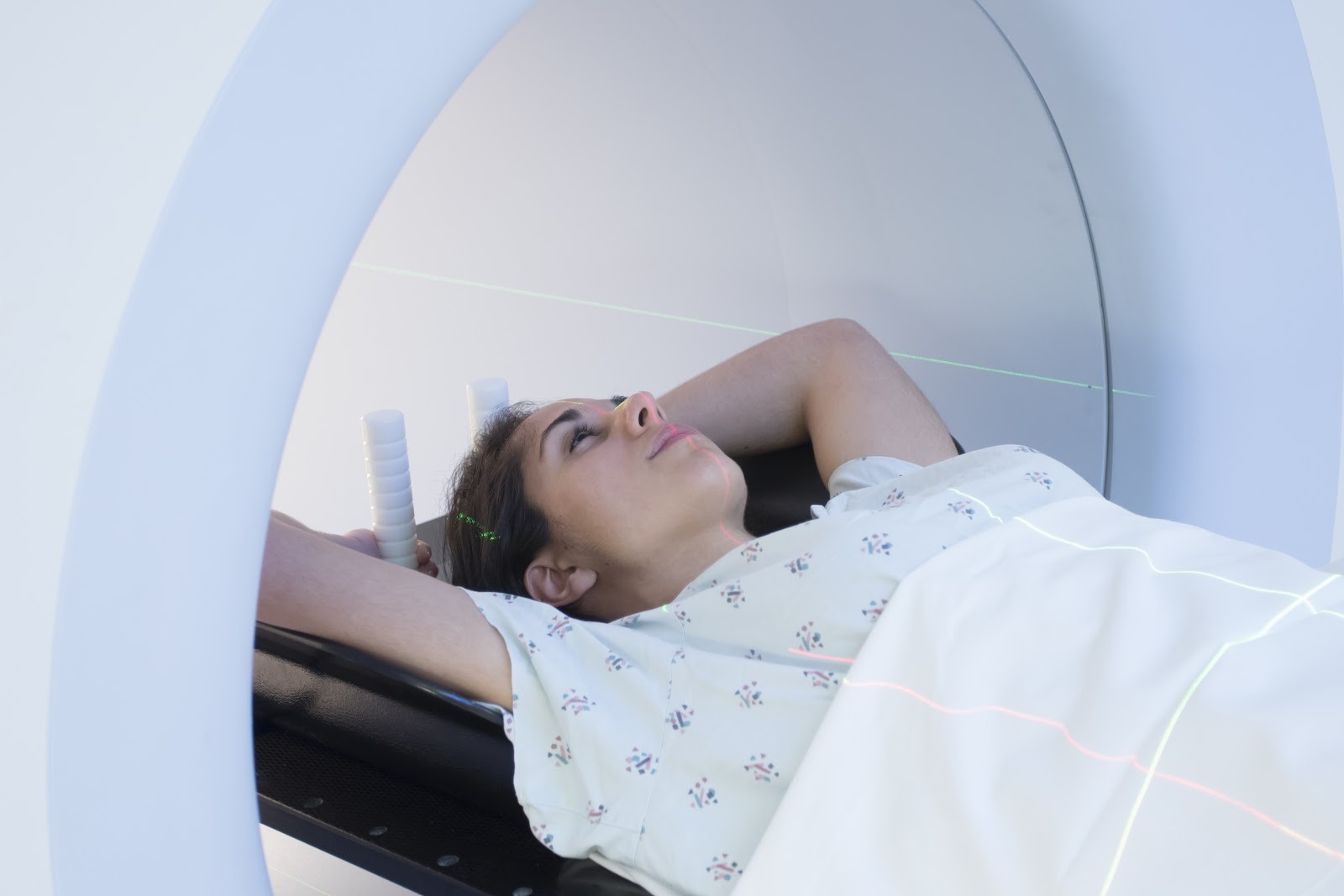 Woman in hospital gown undergoing CT scan imaging procedure