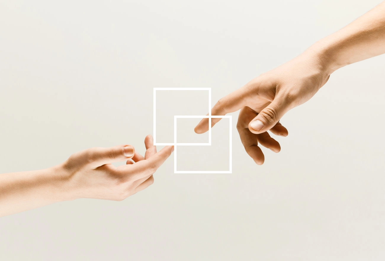Two hands reaching toward each other with white rectangular outlines between them