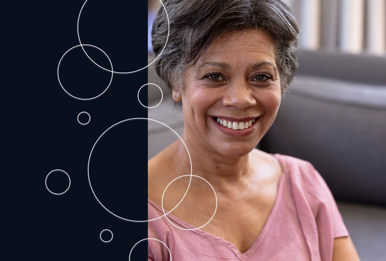 Woman smiling in pink shirt next to dark side with white circles