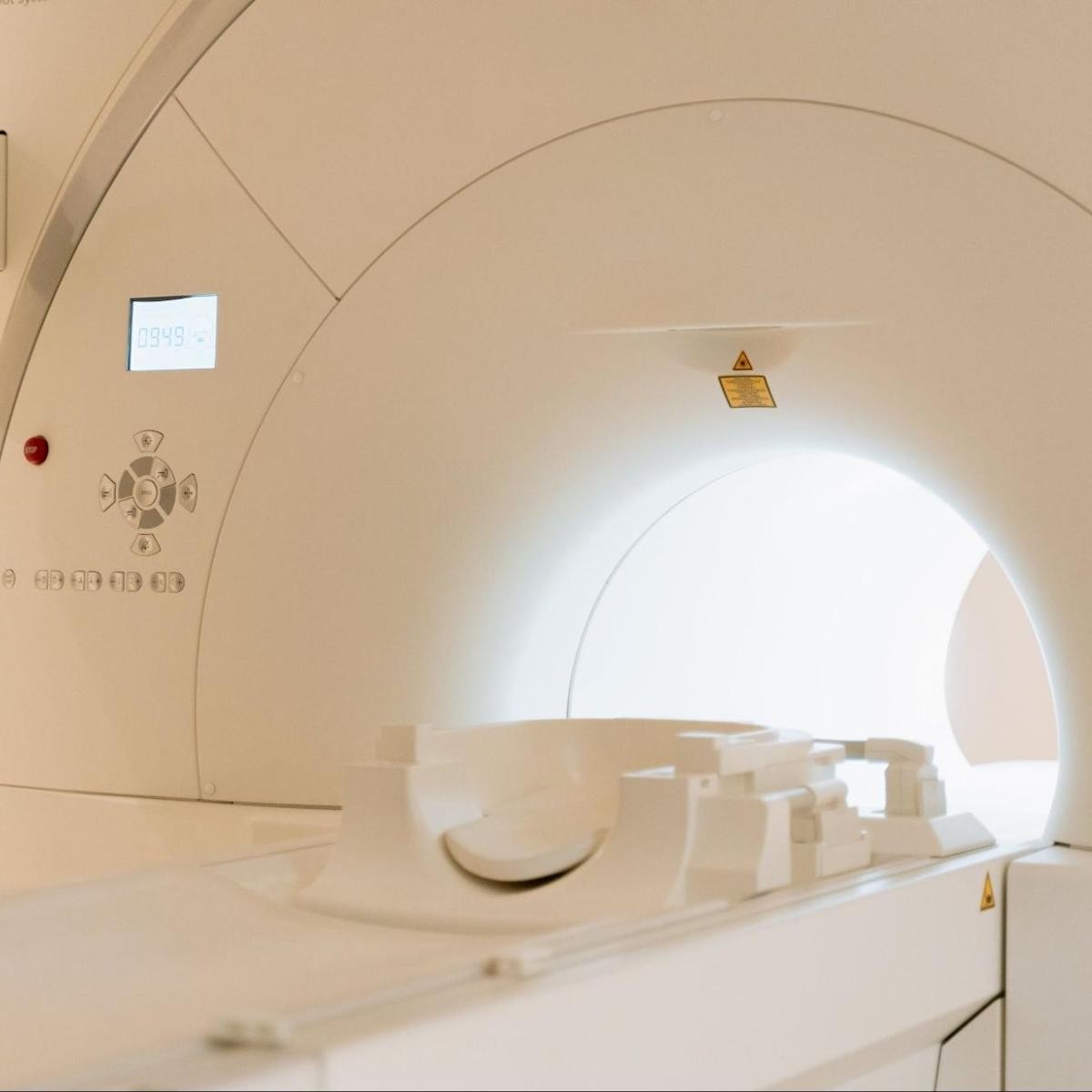 Interior of CT scanner with control panel, display screen, and illuminated circular gantry opening