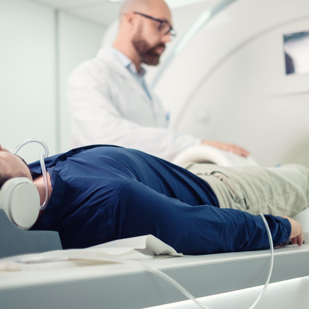 Doctor performing ultrasound examination on patient's leg with transducer probe in medical facility