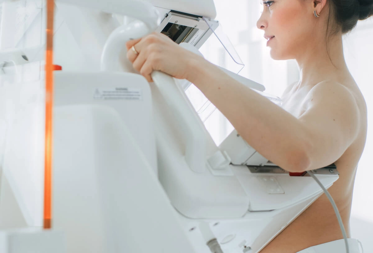 Woman undergoing mammography screening at a medical facility using a diagnostic imaging machine