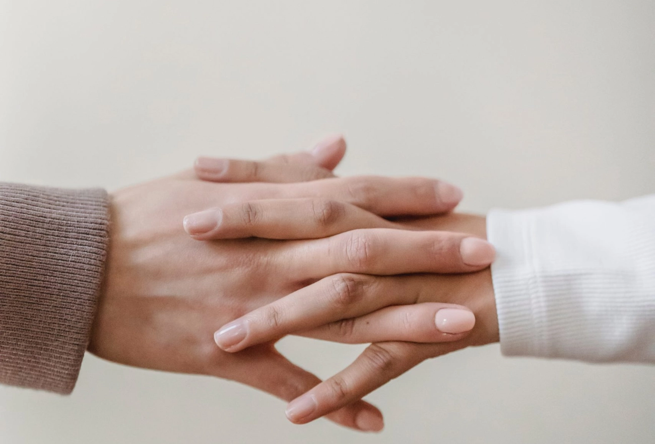 Multiple hands stacked together showing unity, teamwork, and solidarity