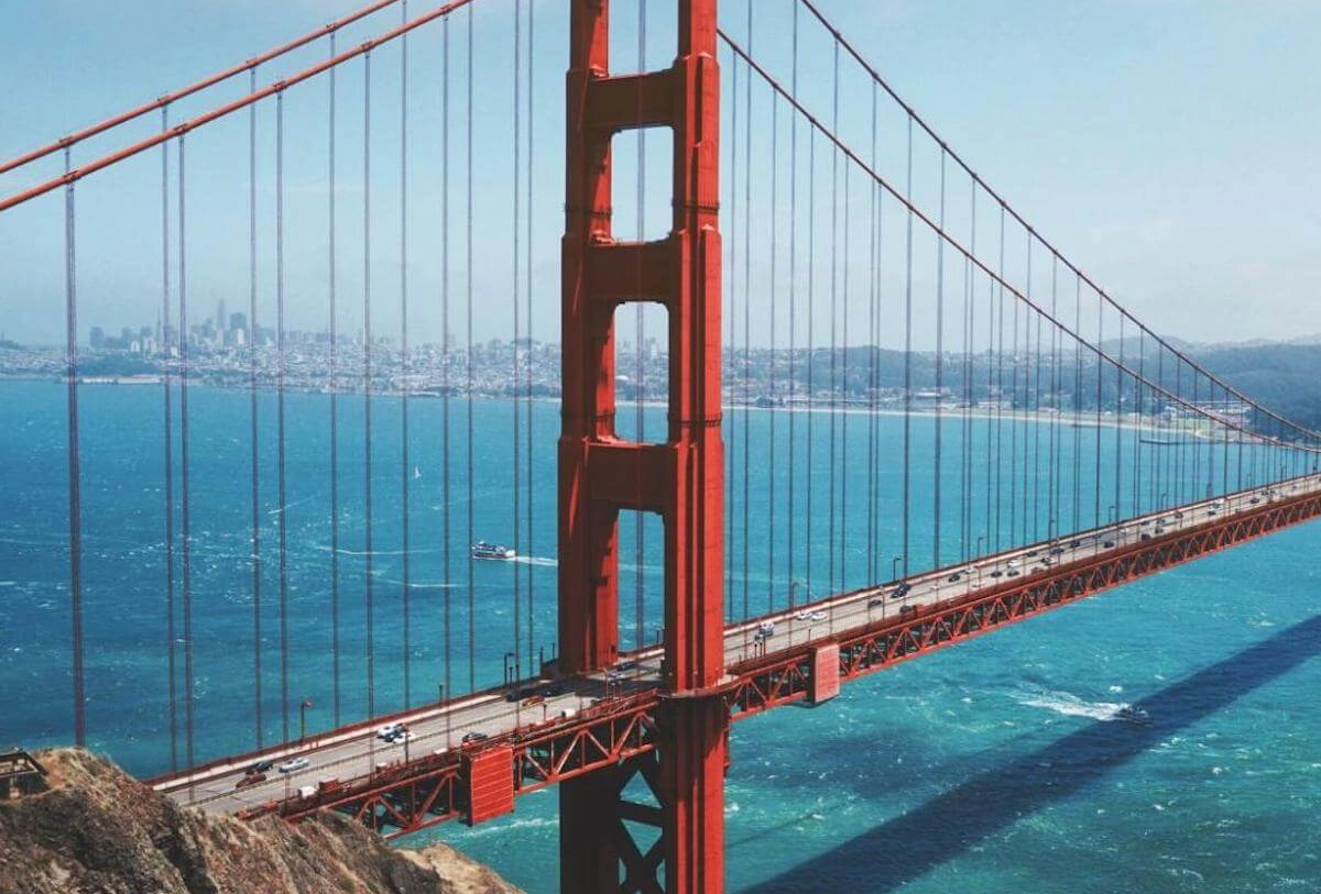 Golden Gate Bridge's red towers and cables spanning San Francisco Bay with cityscape