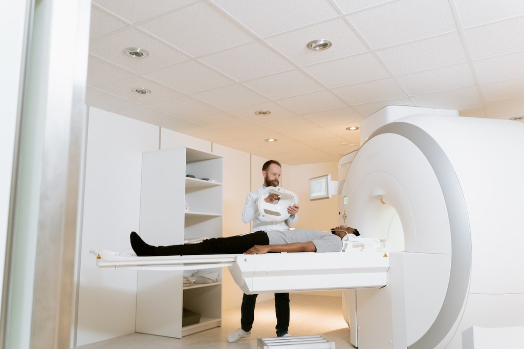 Doctor helping patient in MRI machine