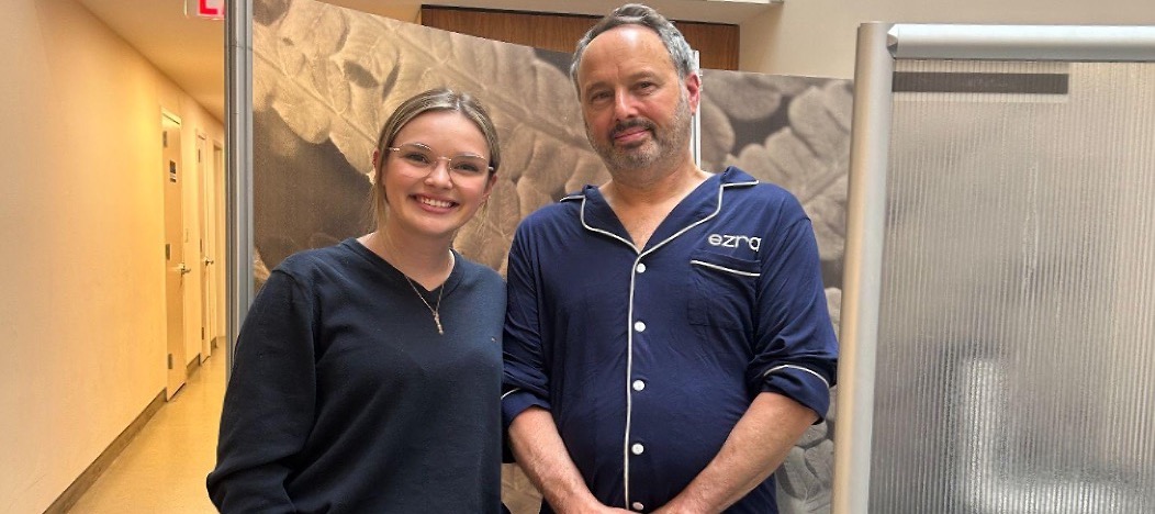 Young woman and man smiling together in medical facility hallway