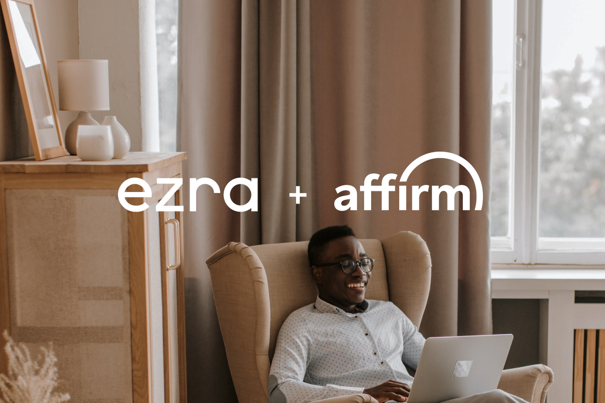 Man working on laptop in modern living room with text overlay 'ezra + affirm