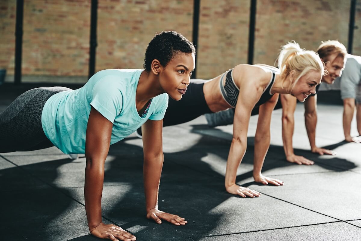 Group of people doing plank exercises in an indoor fitness class
