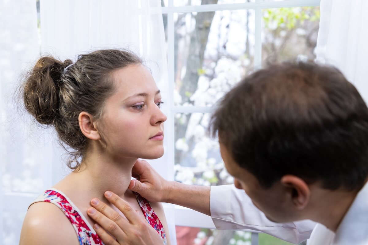Thyroid cancer symptoms: doctor checking a patient