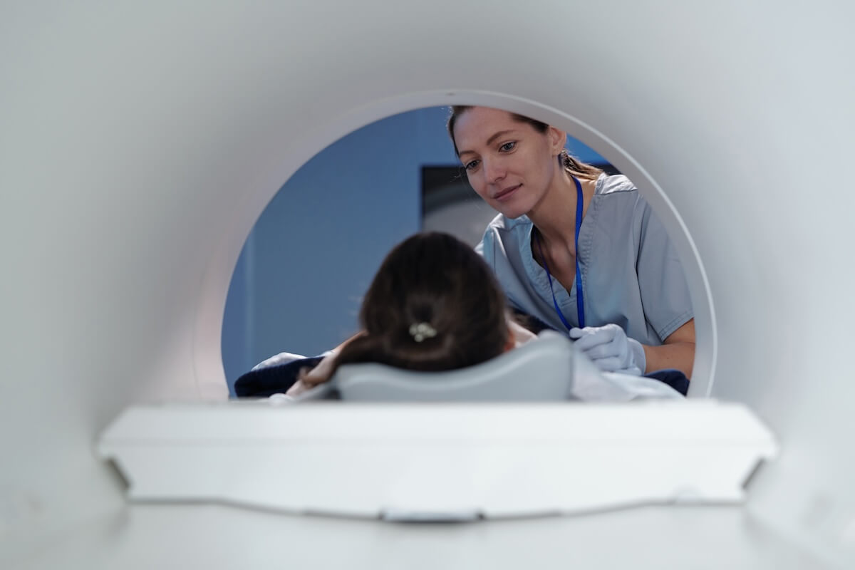 Healthcare professional preparing patient for a MRI scan, view from inside the scanning machine.