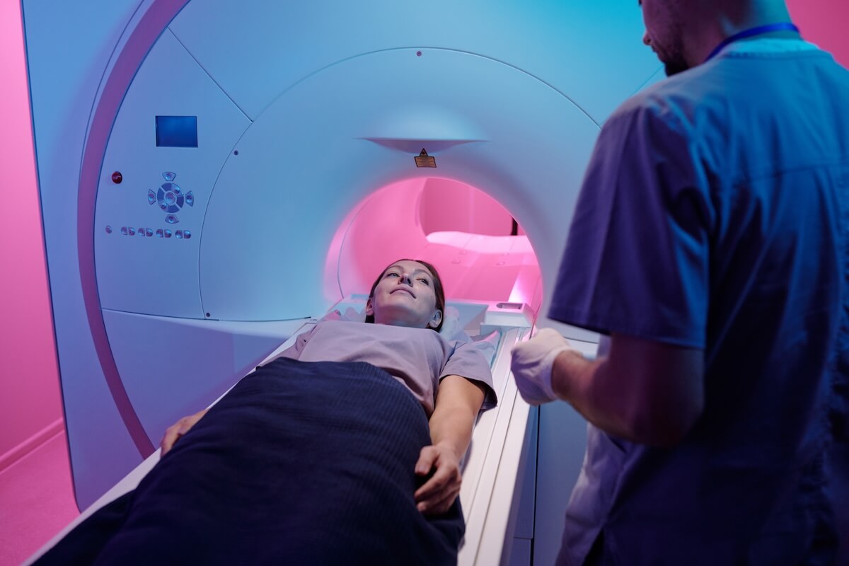 Child undergoing MRI scan with medical technician assisting during diagnostic imaging procedure
