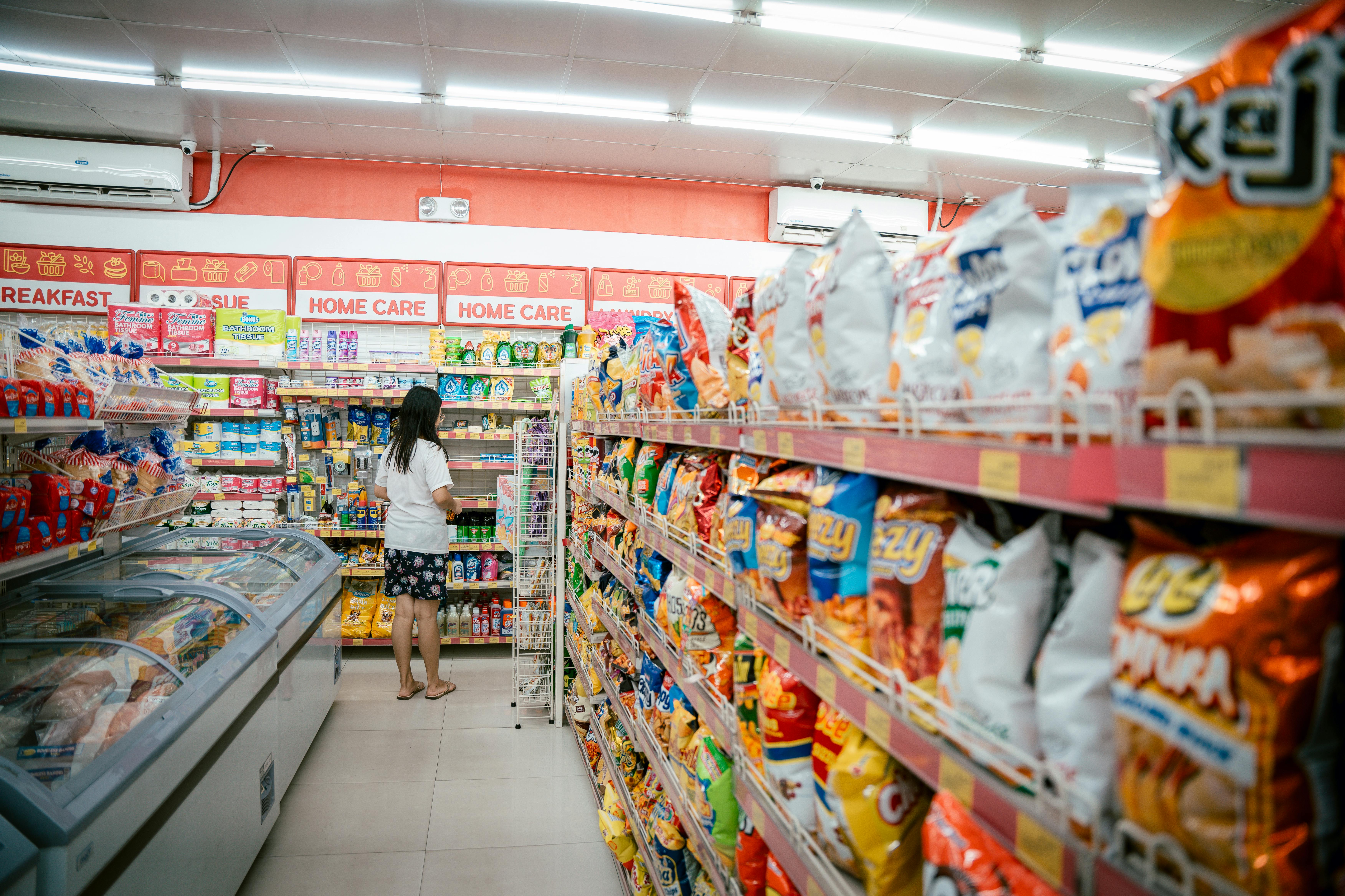 Woman standing at the end of the grocery isle looking at home-care products